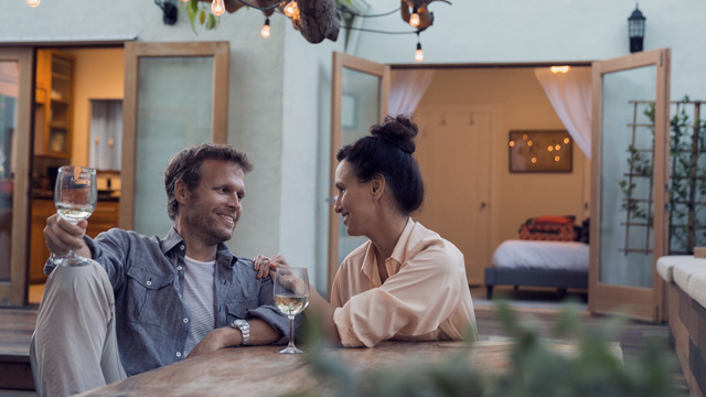 Couple sitting outside their house smiling