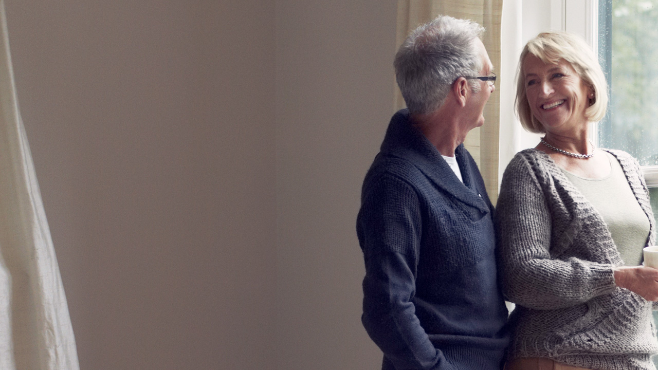 Older couple standing by the window