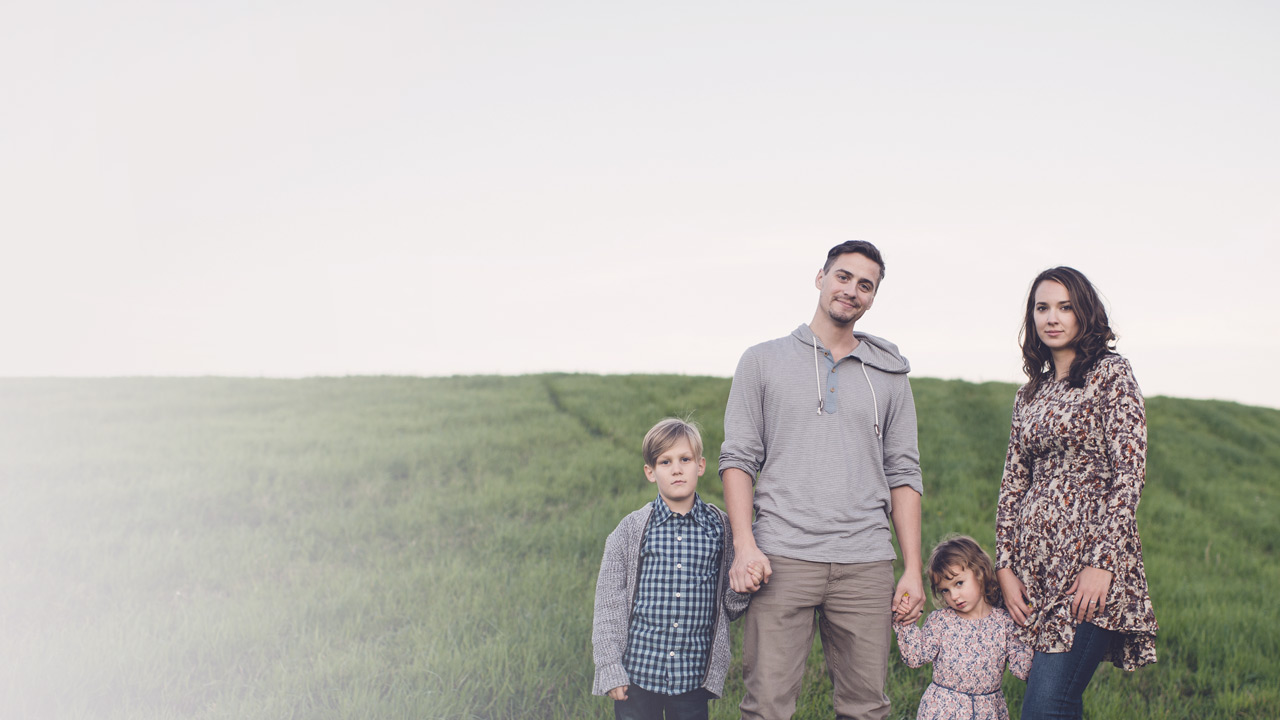 Family with two kids on green field