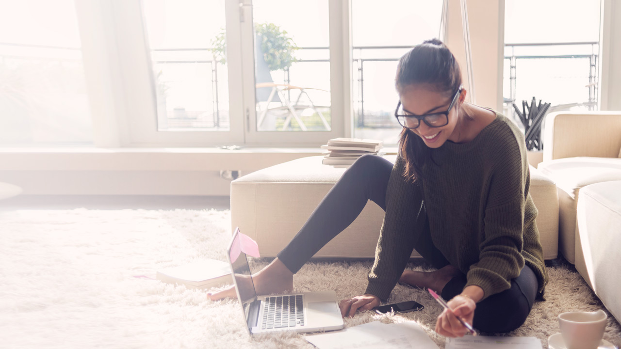 Woman working with computer on white carpet 