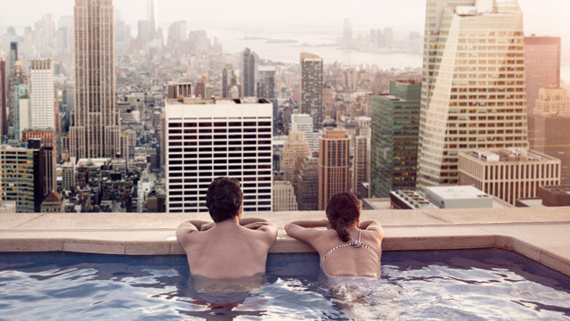 Couple relaxing in pool outdoor city - small