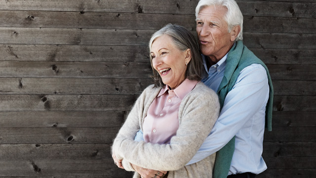 Couple senior smiling and cuddling together in the garden.