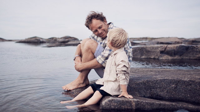 Father and son sitting by sea SMALL