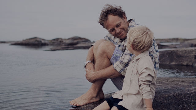father and son by the water smiling small overlay