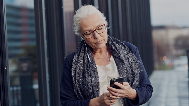senior woman outside building with phone small overlay