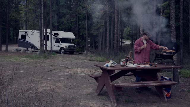 man cooking at campground small overlay