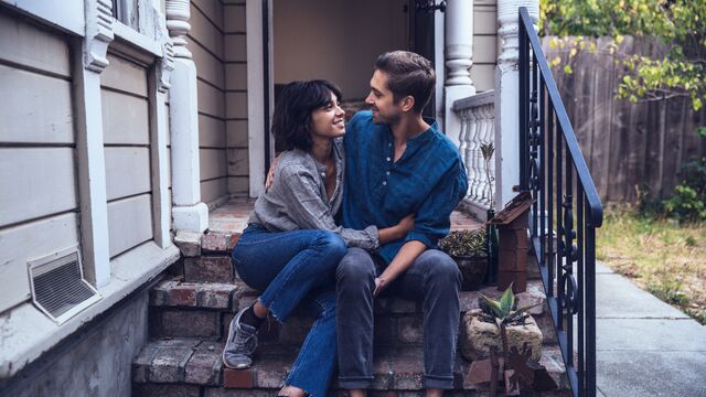 Happy couple sitting on stairs embracing small overlay